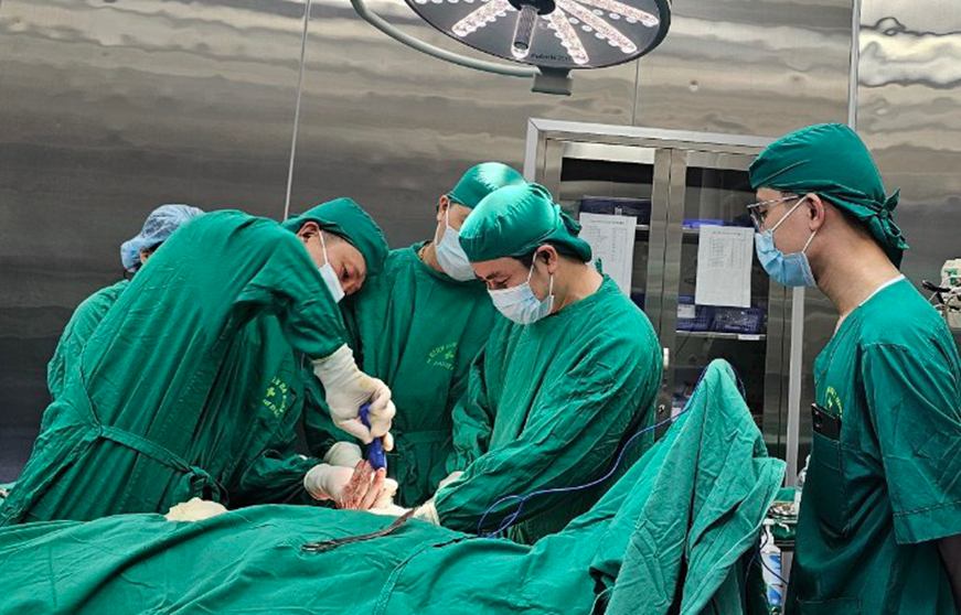 A group of surgeons performing surgery

Description automatically generated